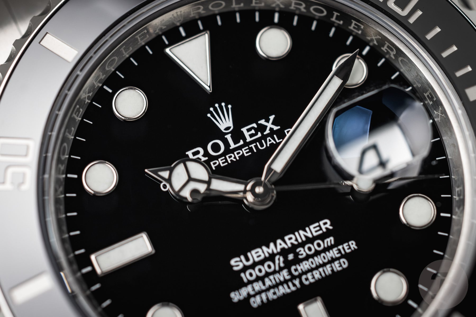 Close-up of a premium superclone Rolex Submariner Date 126610LN showing the black dial, white gold hands, and cyclops date lens with realistic lume plots.