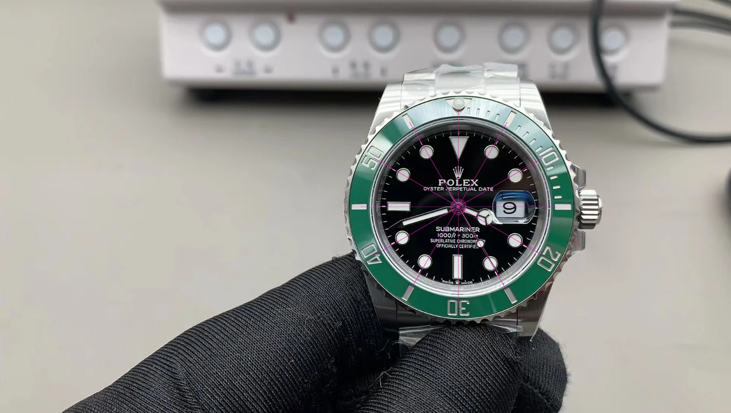 VSF Submariner 126610LV with green bezel, held in gloved hand showing dial details.