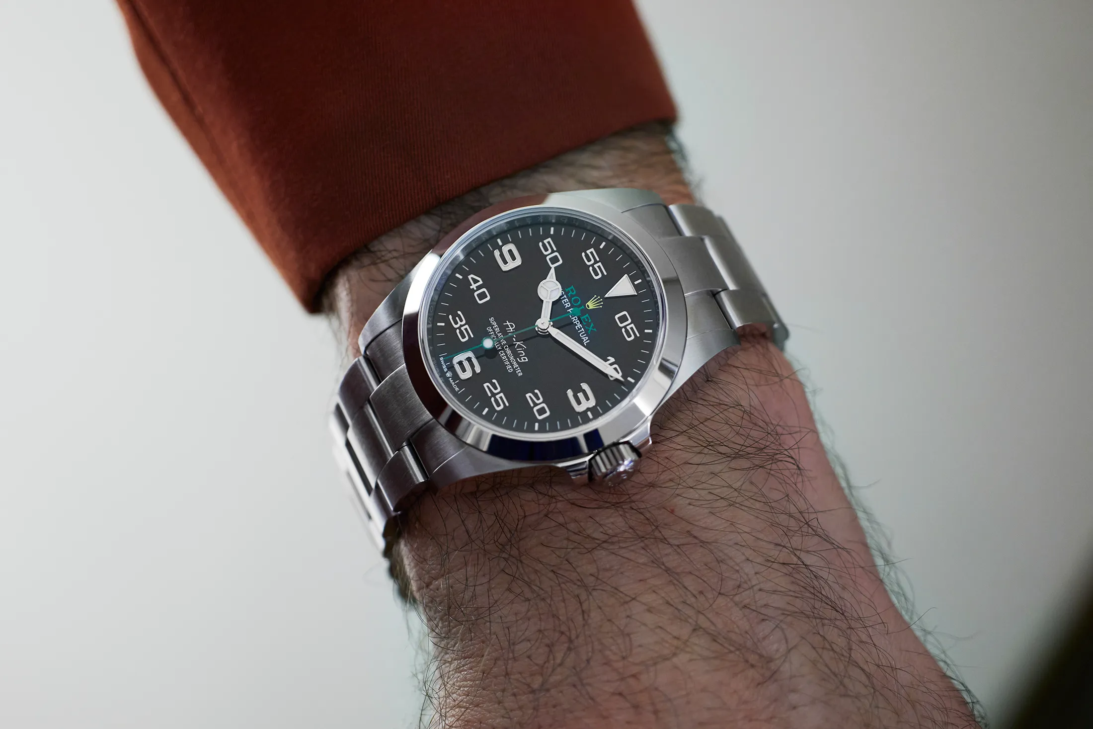Rolex Air-King 126900 superclone black dial on wrist – realistic close-up showing accurate 3-6-9 numerals, green seconds hand, and Oystersteel bracelet in natural light.