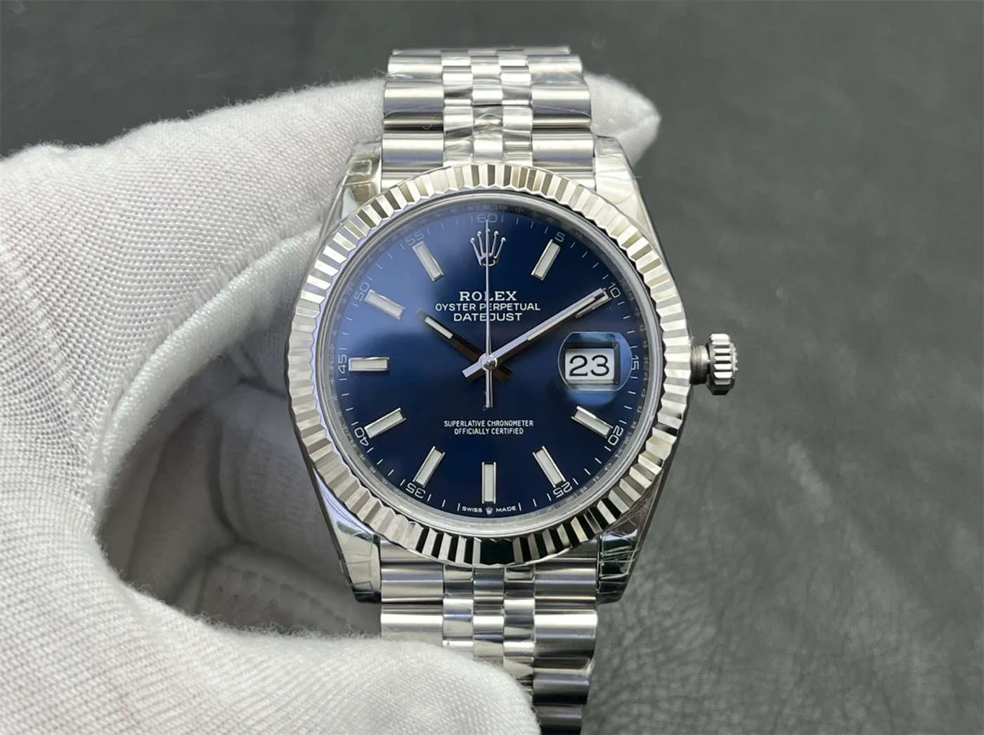Front view of a 2026 Rolex Datejust 41 superclone in Oystersteel with blue dial, fluted bezel, and Jubilee bracelet held in a gloved hand, showcasing the overall proportions and date window at 3 o’clock.