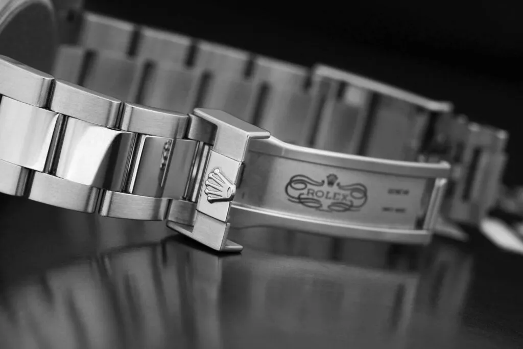 Close-up of genuine Rolex bracelet clasp and engraving, showing precise Rolex crown stamp and serial marking depth.