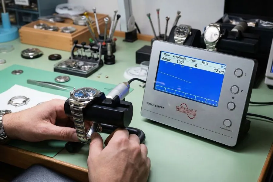 Professional watchmaker using timegrapher on Rolex clone during real accuracy testing setup.