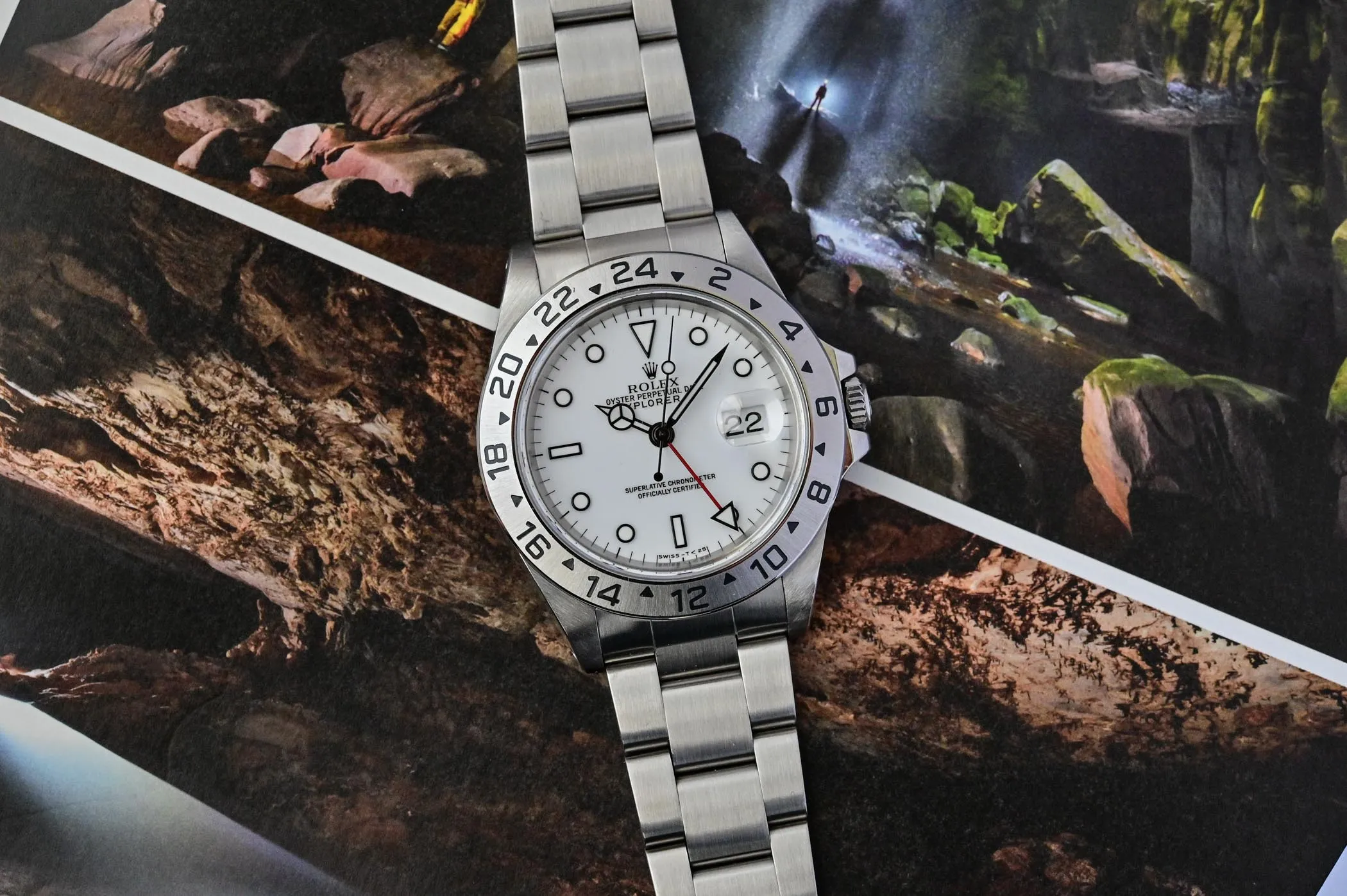 Classic Rolex Explorer II Polar dial superclone displayed against adventure-themed background, highlighting the 24-hour bezel and Chromalight lume markers.